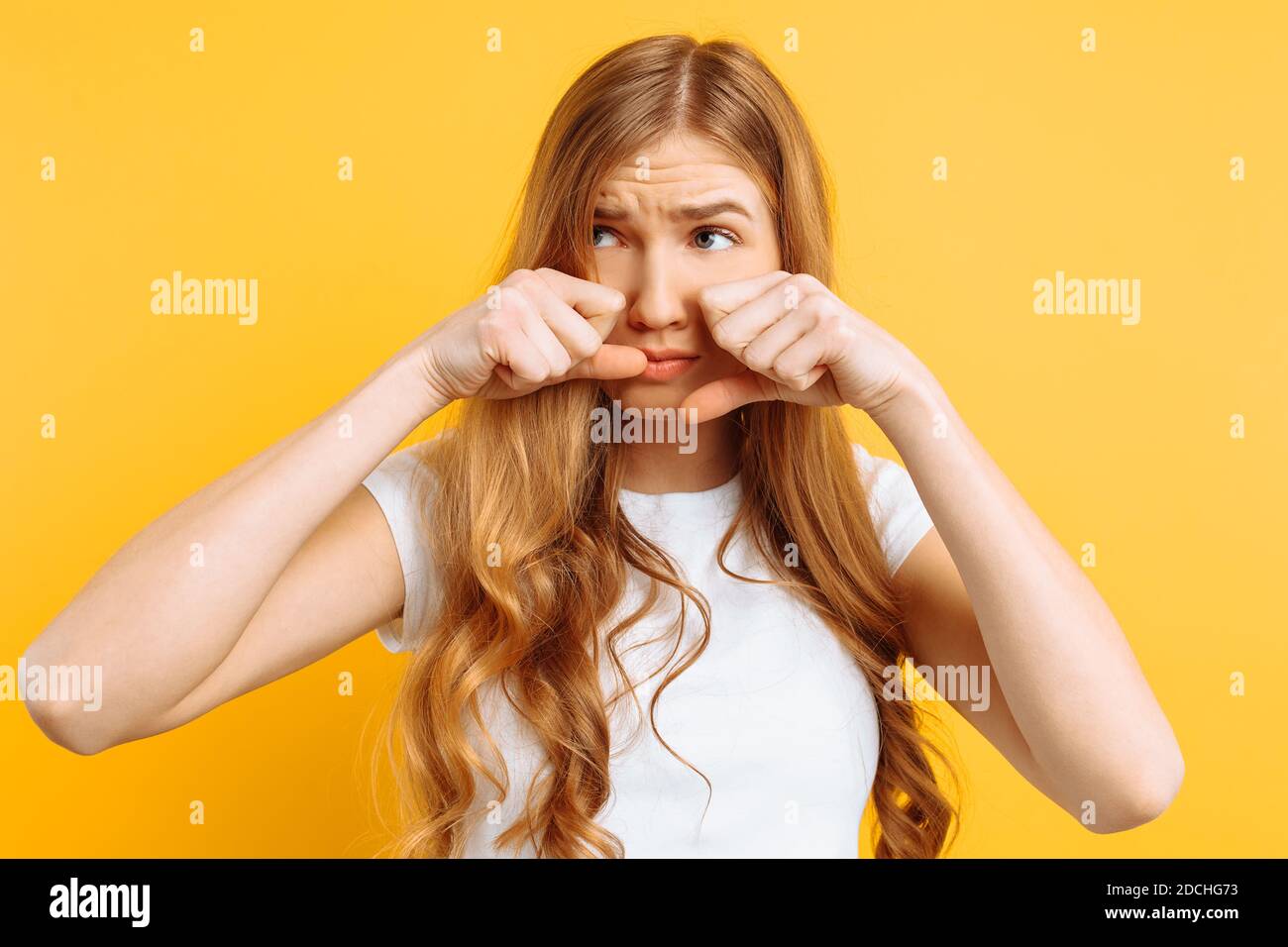 beautiful girl upset, woman crying on yellow background, bad mood Stock Photo