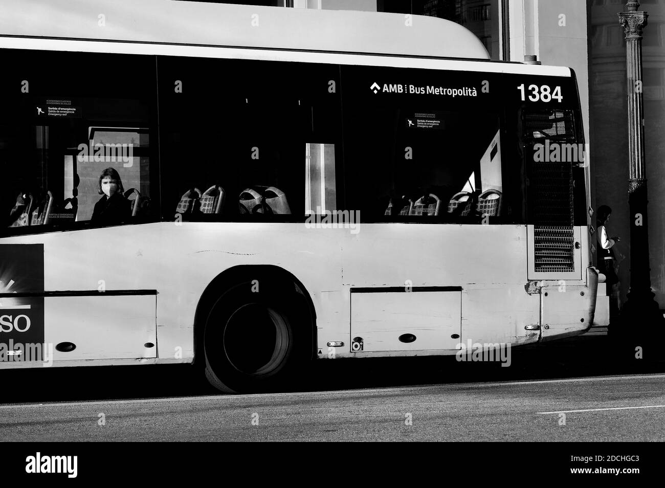 Woman wearing face mask staring out of bus window, Barcelona, Spain. Stock Photo
