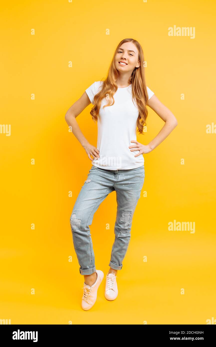 Full length portrait of a cheerful beautiful girl in white t-shirt ...