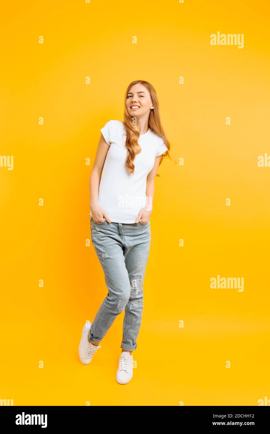 Full length portrait of a cheerful beautiful girl in white tshirt