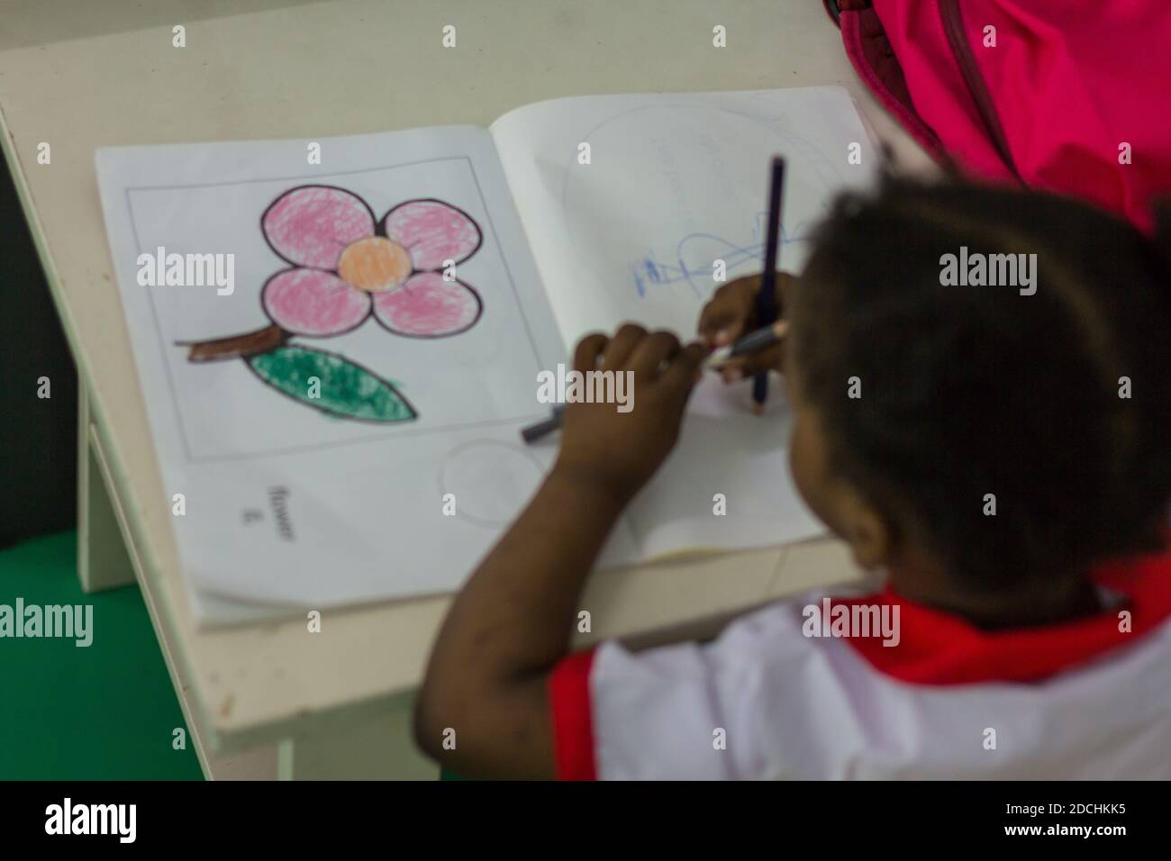 A Pre-schooler makes her drawings of a flower. Stock Photo