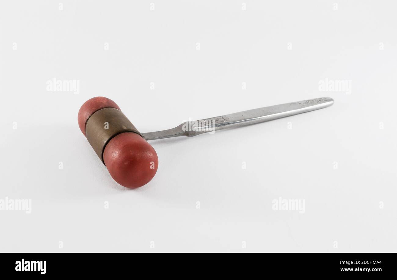 Isolated old vintage reflex hammer on white background. This medical instrument is used to check reflexion ability and for checking nerves. Stock Photo