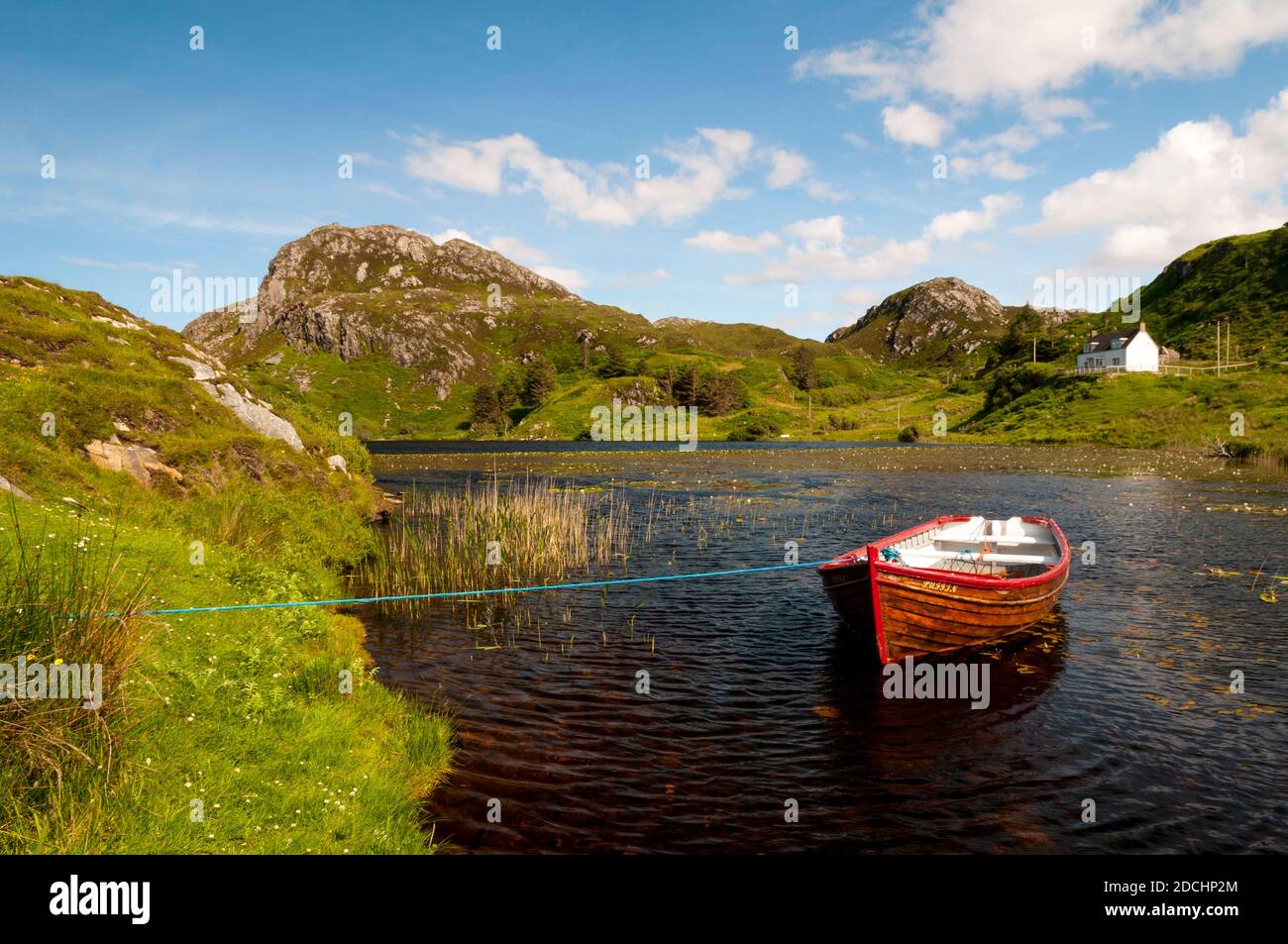A small rowing boat moored on Loch Dubh at Tarbet on the north west coast of Scotland. June. Stock Photo