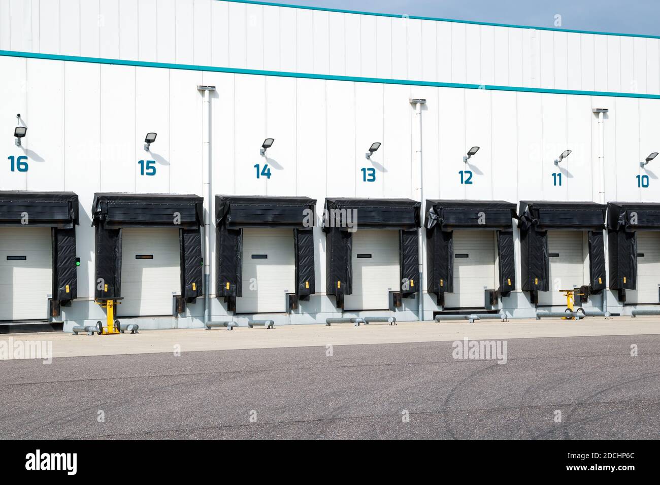 Row of loading docks with shutter doors at an industrial warehouse. Stock Photo