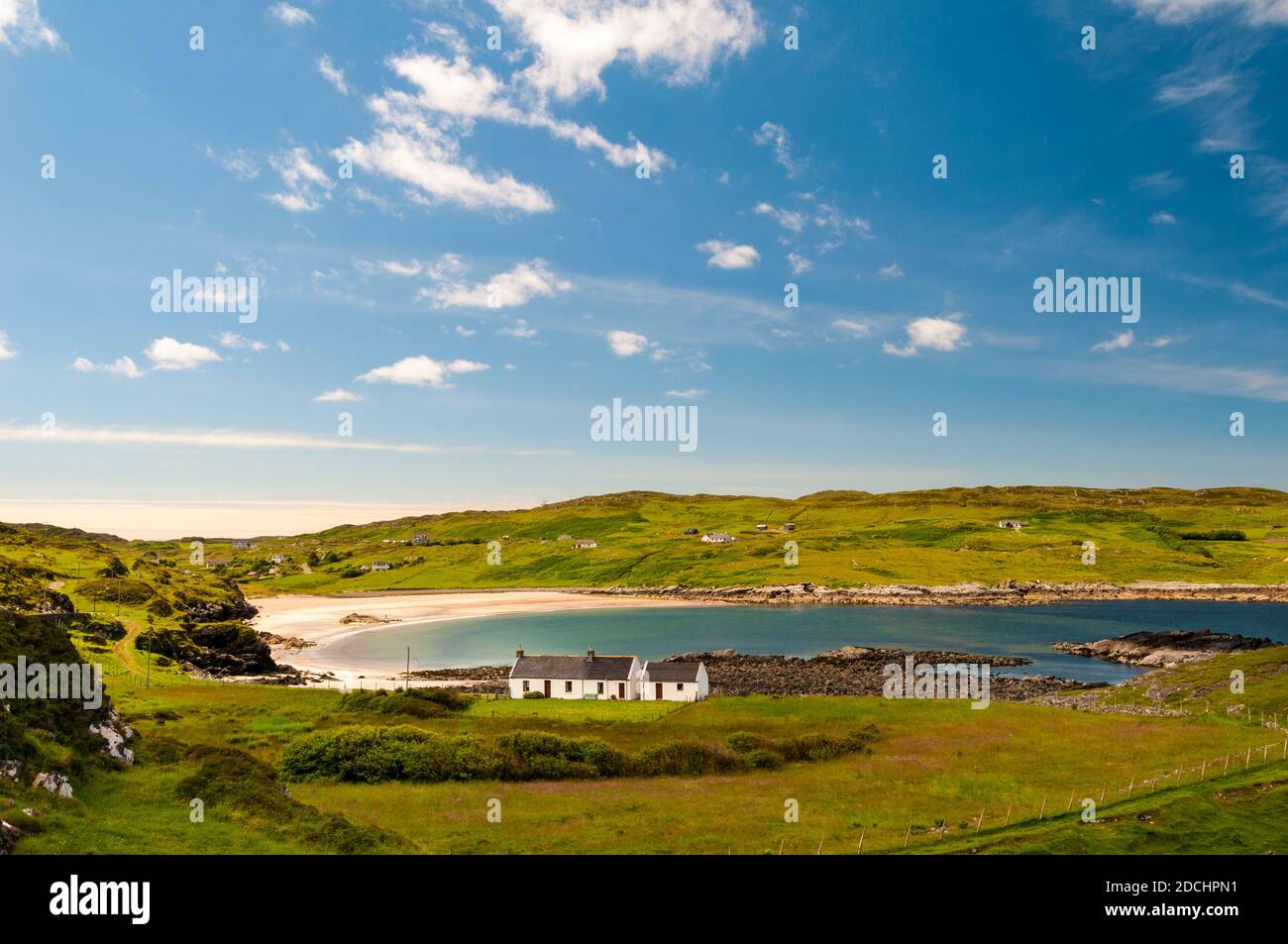White cottages in front of the sweeping curve of the white sand beach at Clashnessie Bay in the far north of Scotland. June. Stock Photo