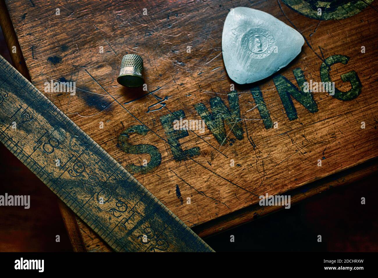 Wooden scale,chalk and thimble on wooden sewing table close up view at Dege & Skinner. Stock Photo