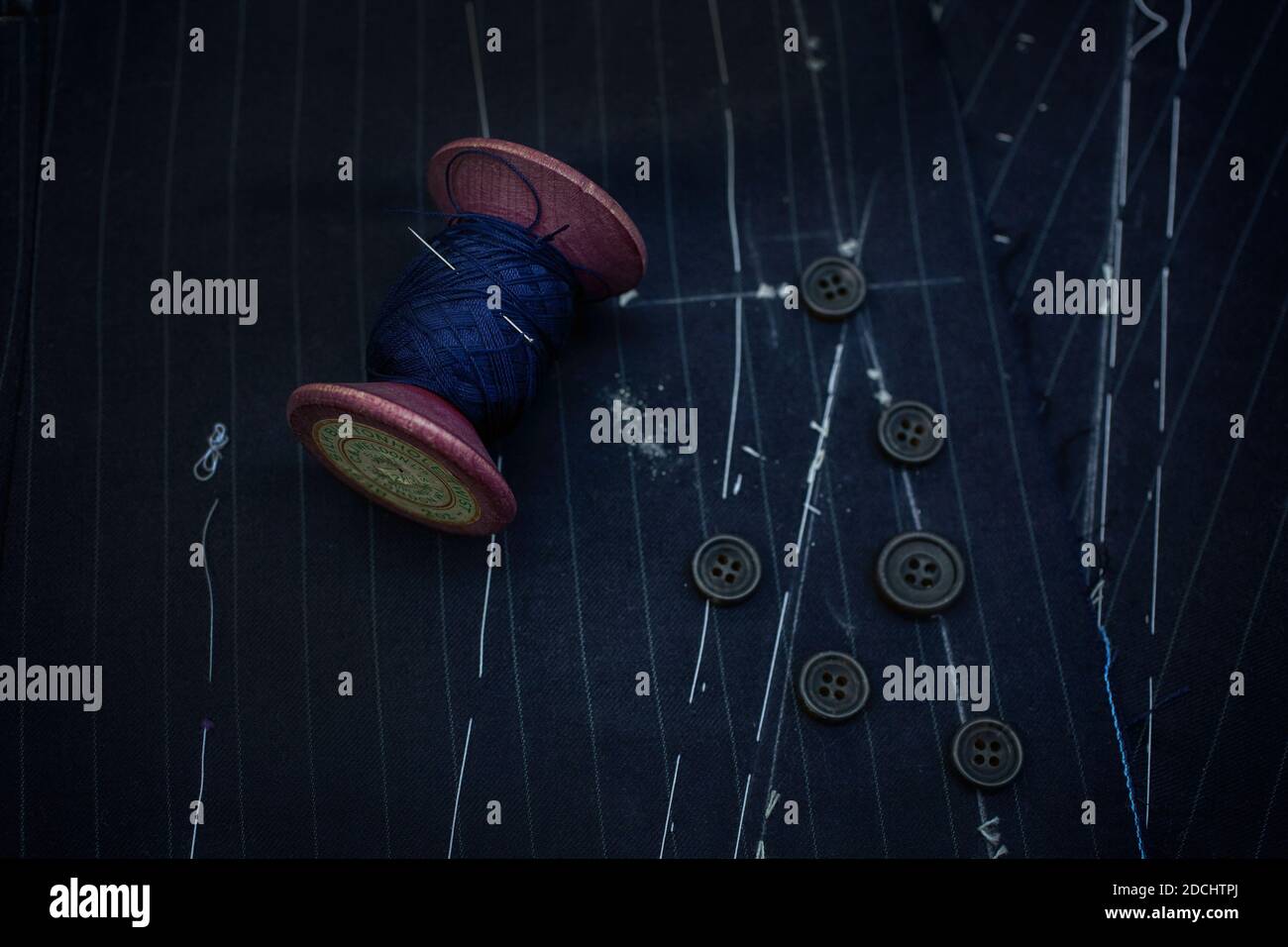 Yarn ,needle ,buttons with fabric in a close up view at Gieves & Hawkes &Hawat Savile Row, London,United Kingdom. Stock Photo