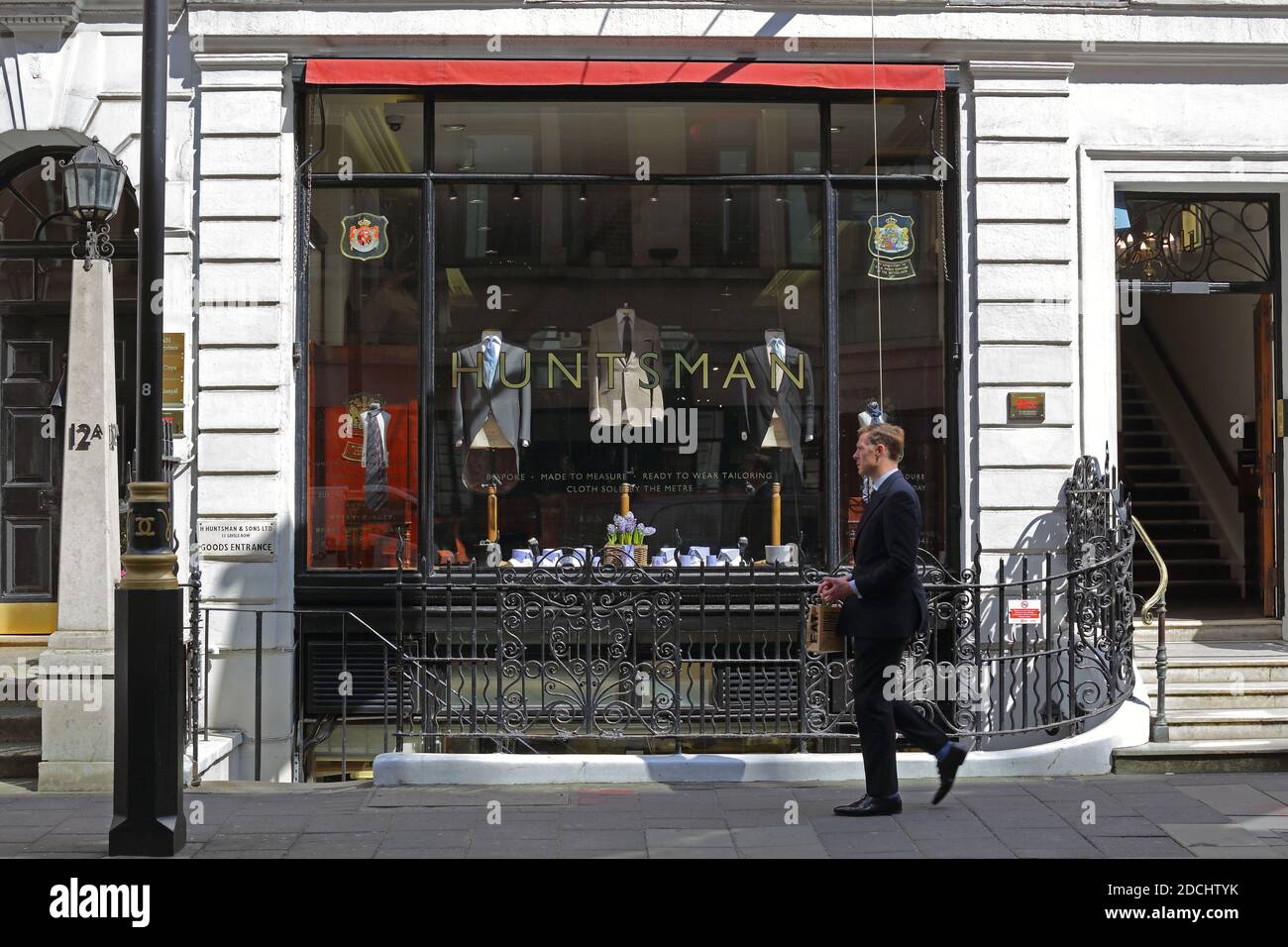 United Kingdom /London /Savile Row/ Man passing by the Huntsman Savile Row tailor. Stock Photo