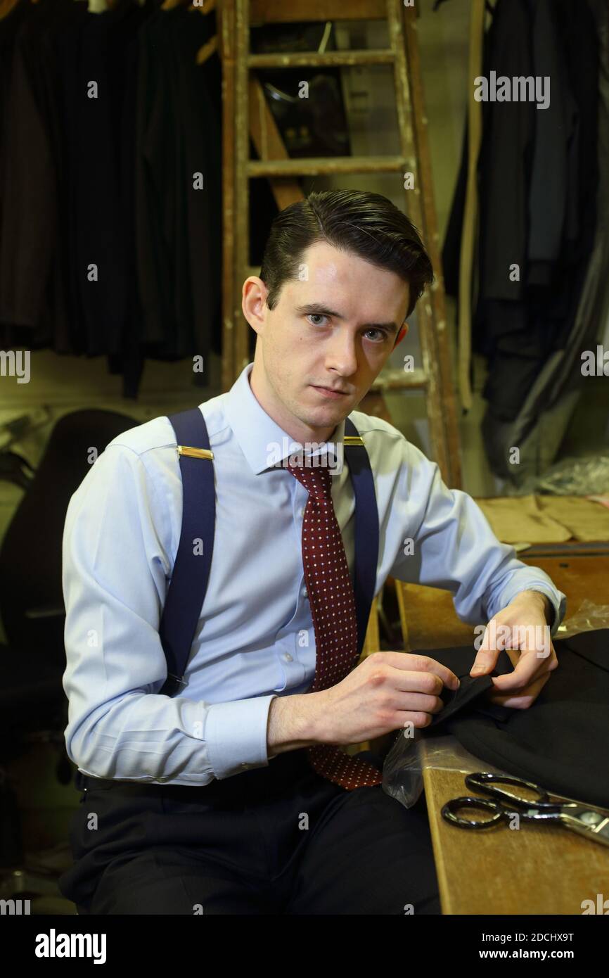 Portrait of young Savile Row tailor making suit at tailoring shop. Stock Photo