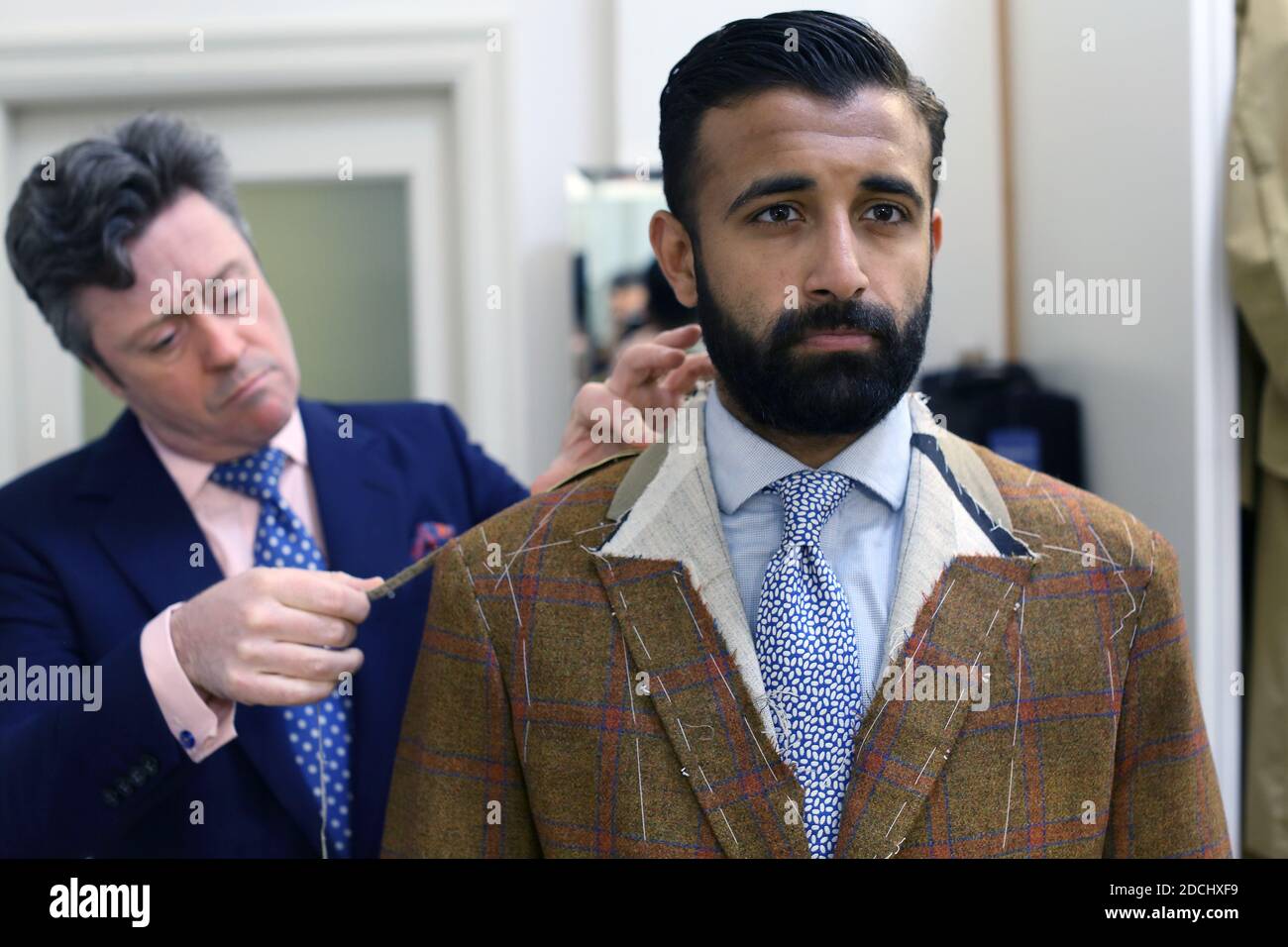 Tailor takes measures of costumer at Richard Anderson bespoke Savile Row Tailors . Stock Photo