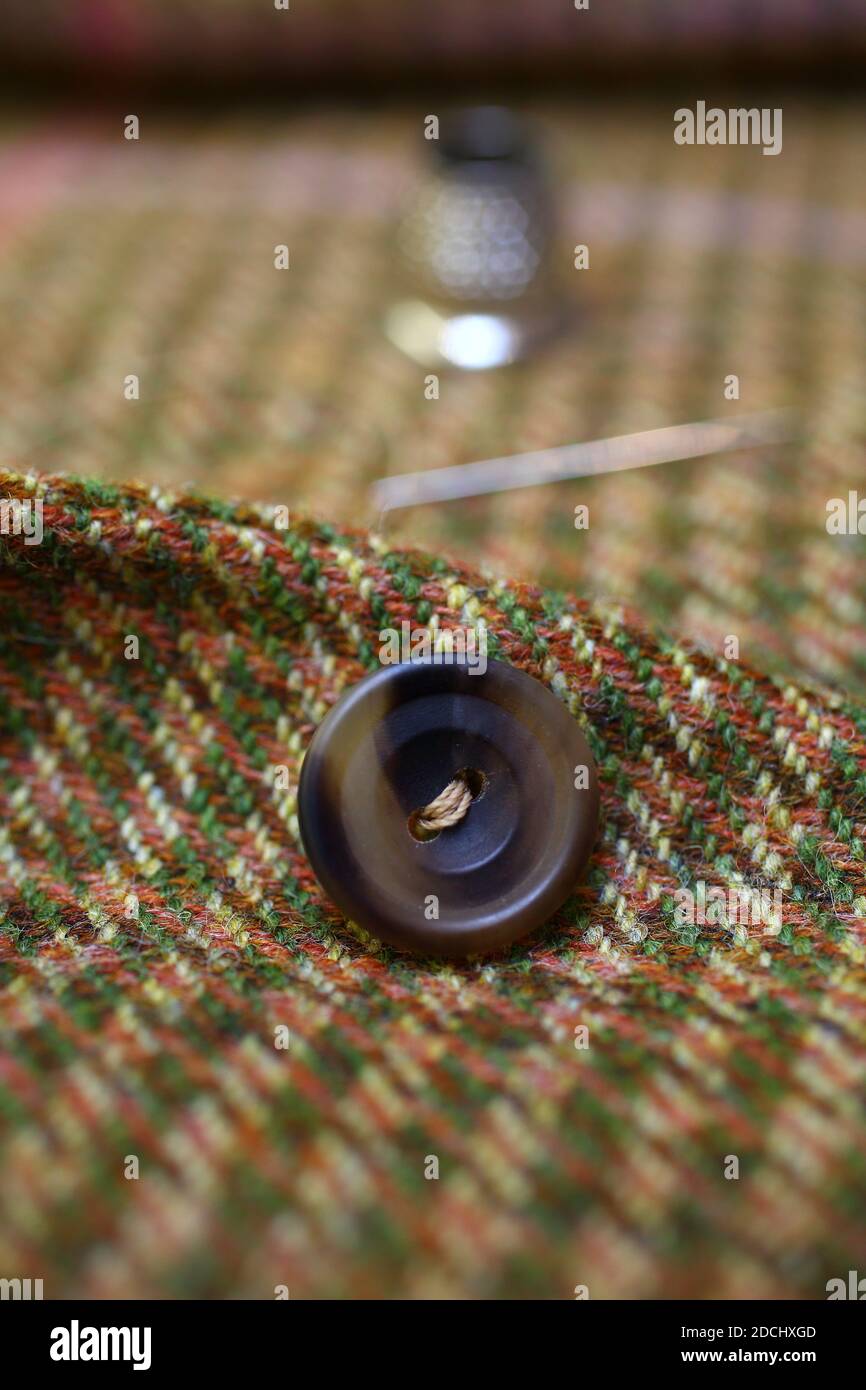 Sewing on a button. Savile Row , London Stock Photo