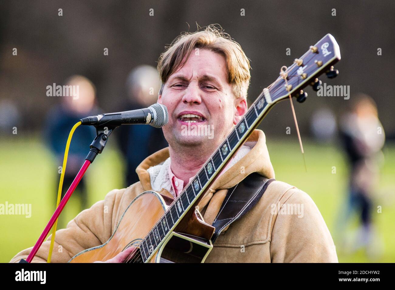 Munich, Bavaria, Germany. 21st Nov, 2020. Christian Stockmann of Christen im Widerstand sings at a corona rebel ''church service''. Bypassing a ban on ''Hygienedemos'' in Munich, the Coronarebels organized as a church service (Gottesdienst) that ultimately took place in the English Garden. The event was organized by multi-activist Frank Winkler who is associated with animal rights groups as well as Parents for Future, but more recently has been active since the beginning of the Corona conspiracy theory and anti-mask demonstrations, now moving up to the core of the organizational structure Stock Photo