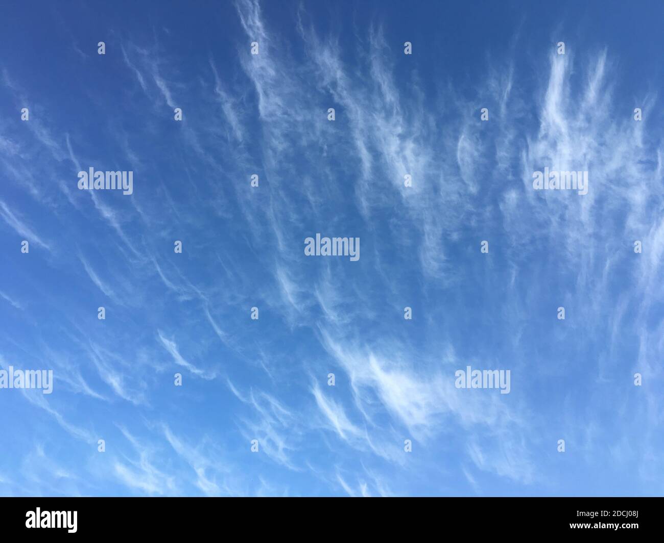Delicate white feather clouds on the blue sky. Stock Photo