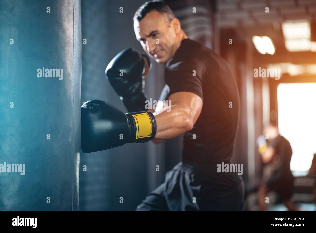 athletic sport man boxer training with punching bag or exercising in gym Stock Photo