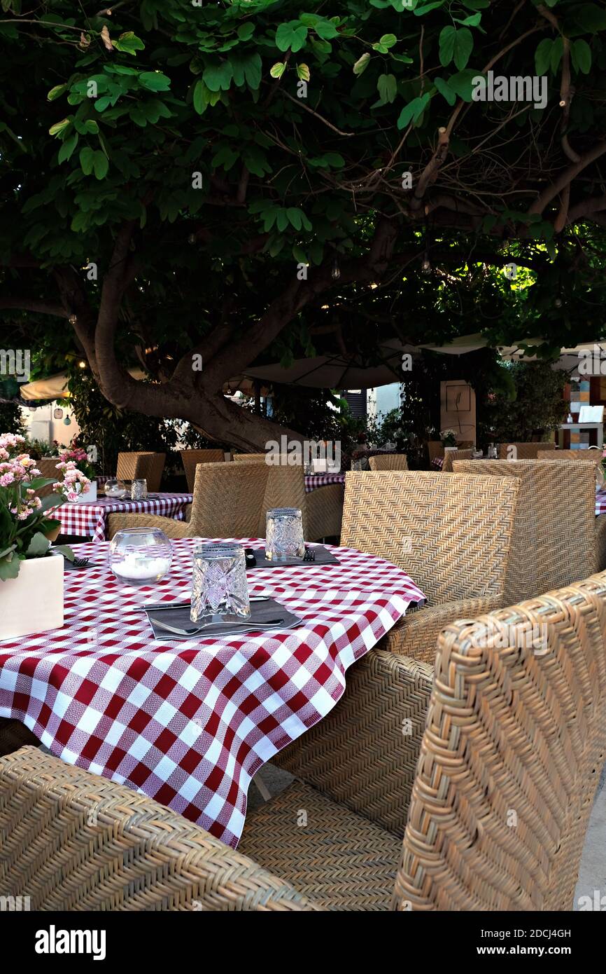 Colorful tables and chairs in an open restaurant in Pula, Italy Stock Photo