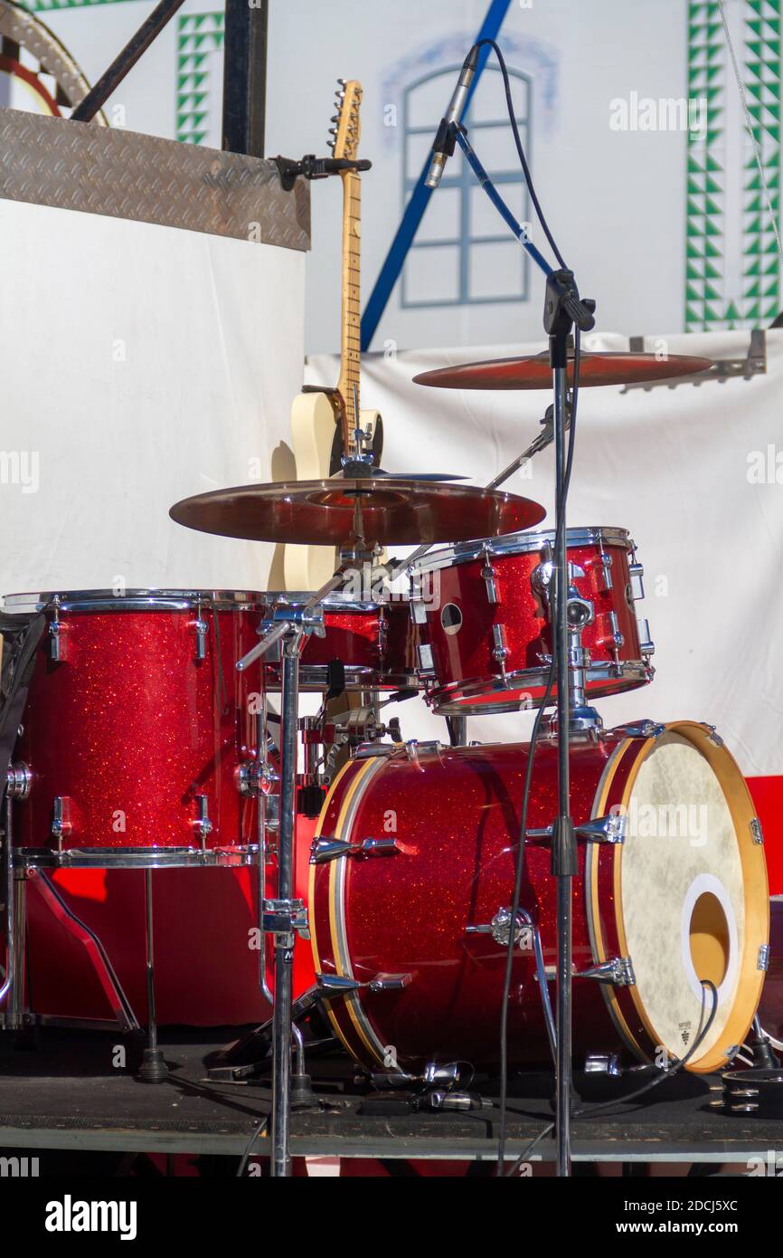 Red drum on stage before a concert with an electric guitar in the background Stock Photo