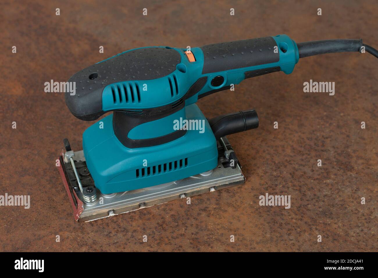 Electric sheet finishing sander on old rusty metal sheet., on