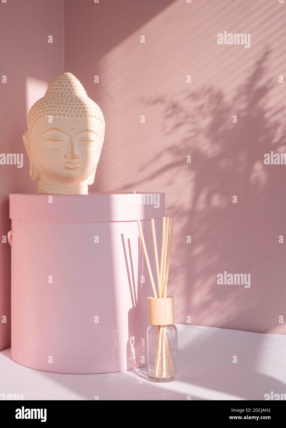 White Buddha bust on pastel pink background Stock Photo