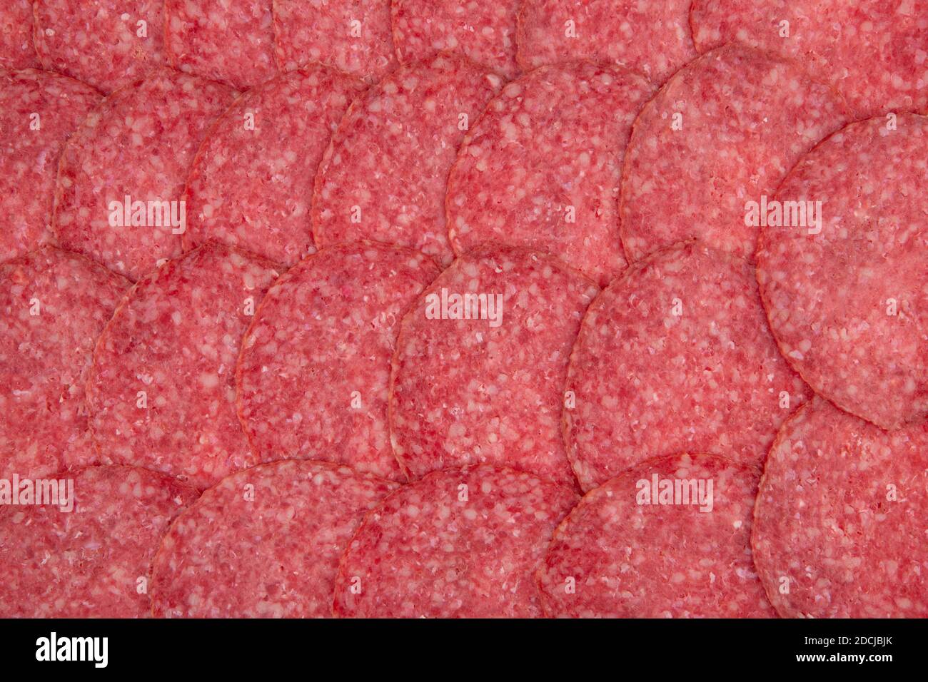 Salami texture top view and closeup of neatly stacked salami slices
