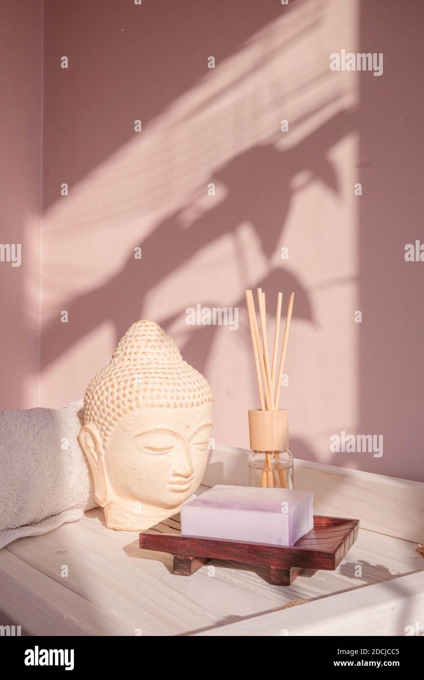 White Buddha bust on pastel pink background Stock Photo