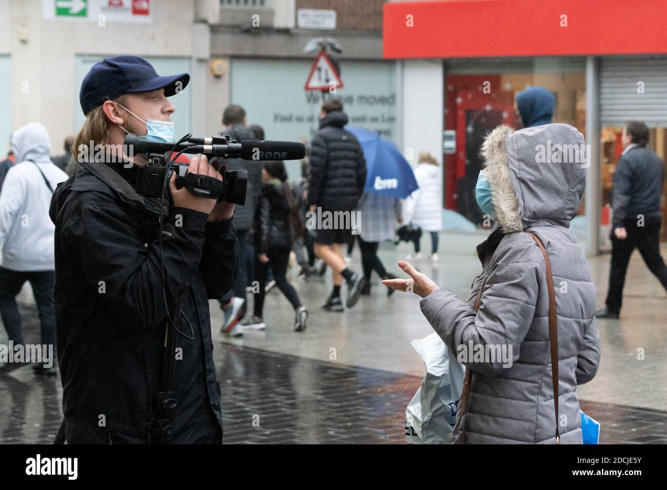 Liverpool city centre, 21st Nov 2020: A woman is interviewed in the rain by a reporter during an anti lockdown protest march Stock Photo