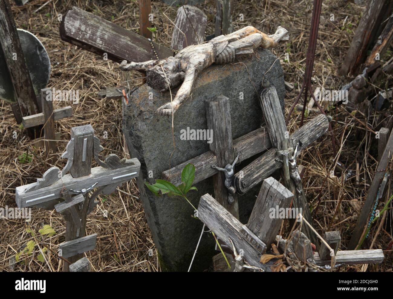 Broken figure of Jesus Christ from the crucifix beside the wooden crosses on the Hill of Crosses near Šiauliai in Lithuania. The most important Lithuanian pilgrimage site is located some 12 km from the town of Šiauliai. Nobody has ever tried to count how many large and small crosses are actually installed on the hill, but it is believed there are at least two hundred thousand crosses here. And every day dozens or even hundreds of new crosses are added by pilgrims from all over the world. Stock Photo