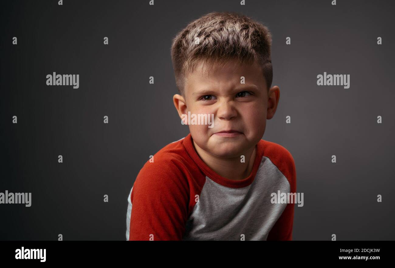 Drama boy showing with his face I Dont Like You to his parents isolated on grey background. Fake child emotions. Human emotions, facial expression Stock Photo