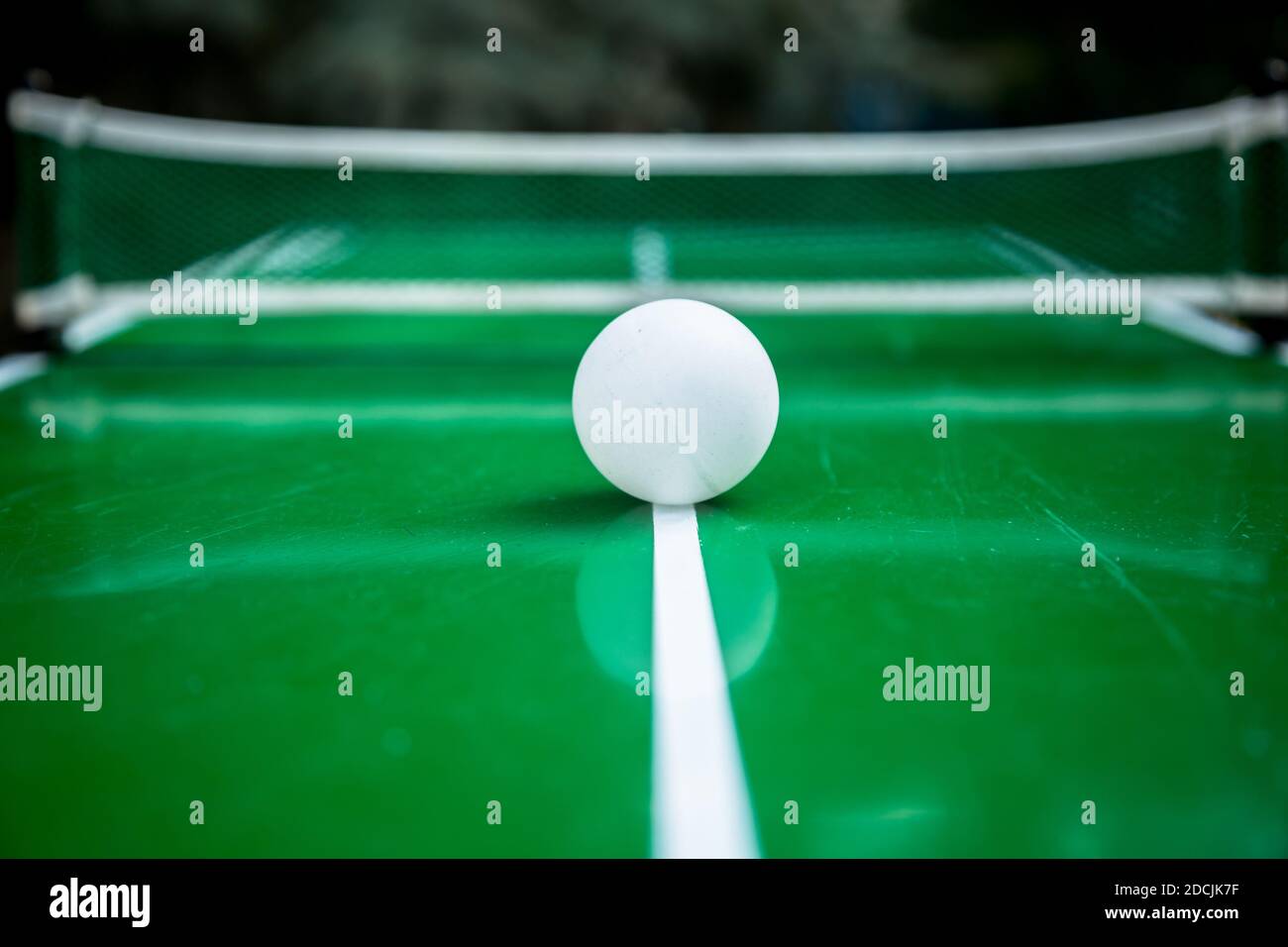 Table tennis ball with green background. Outdoor photo, shot in summer