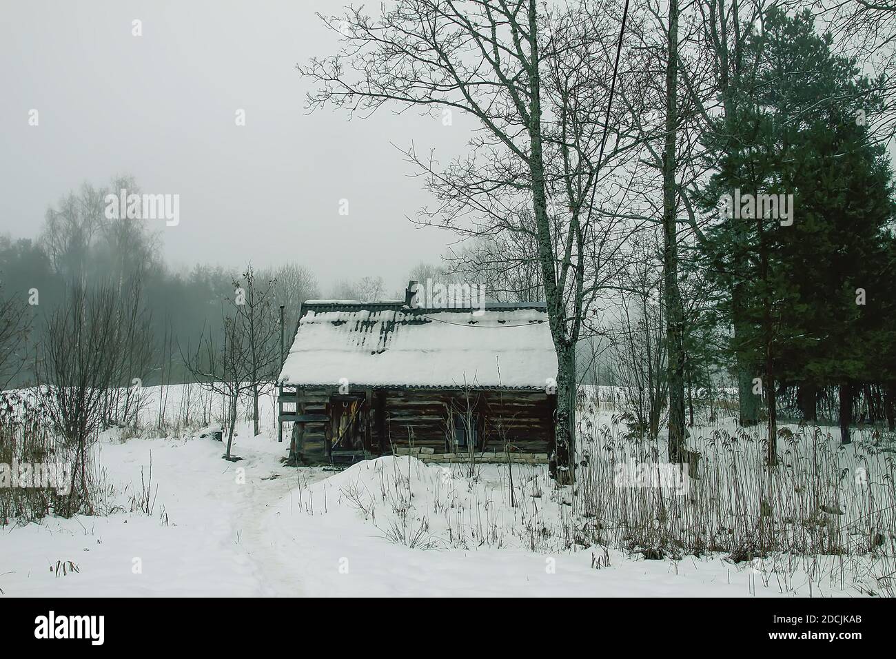 Old wooden building of bathhouse in the village in winter day. Traditional exterior oin Russian style. Stock Photo