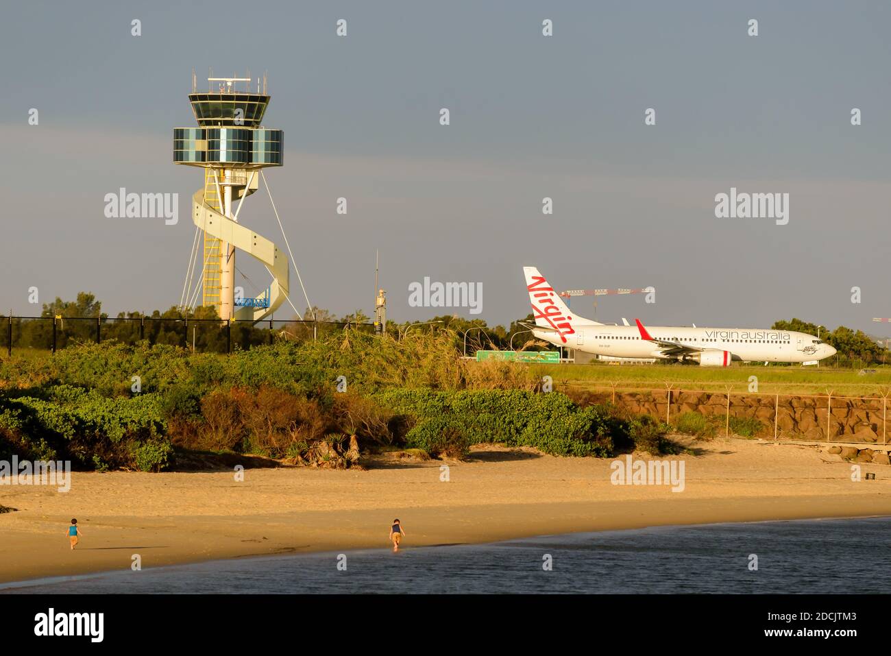 Virgin Australia Boeing 737 taxiing at Sydney Airport close to the Plane Spotting Beach in Mascot, Australia. Air Traffic Control tower behind. Stock Photo