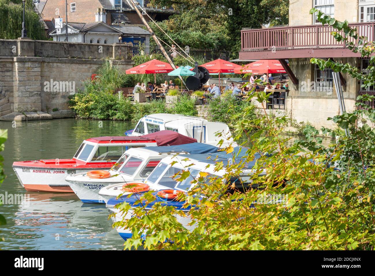River cruise boats and cafe across River Avon from Christchurch Meadow Walk, Oxford,  Oxfordshire, England, United Kingdom Stock Photo