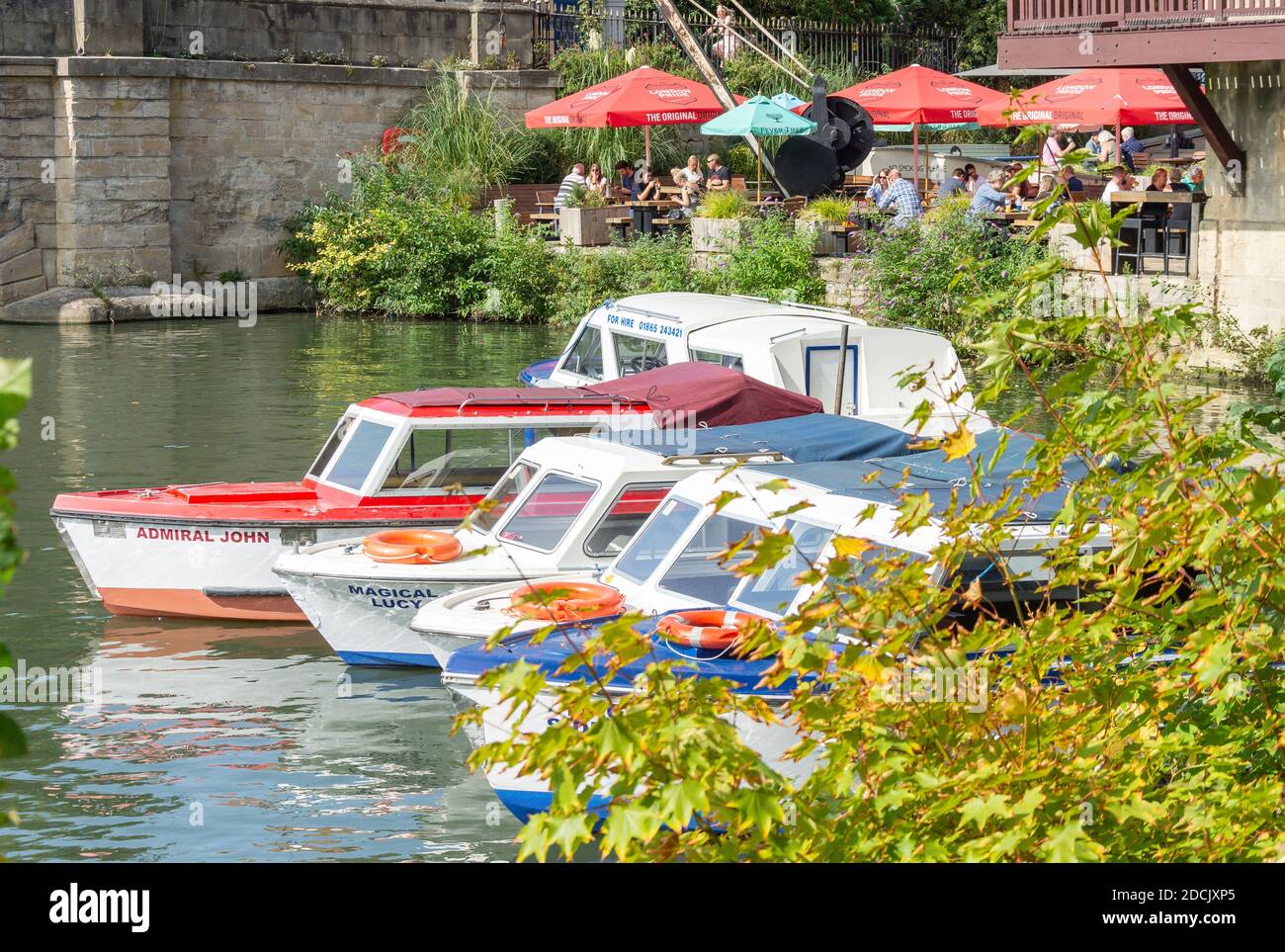 River cruise boats and cafe across River Avon from Christchurch Meadow Walk, Oxford,  Oxfordshire, England, United Kingdom Stock Photo