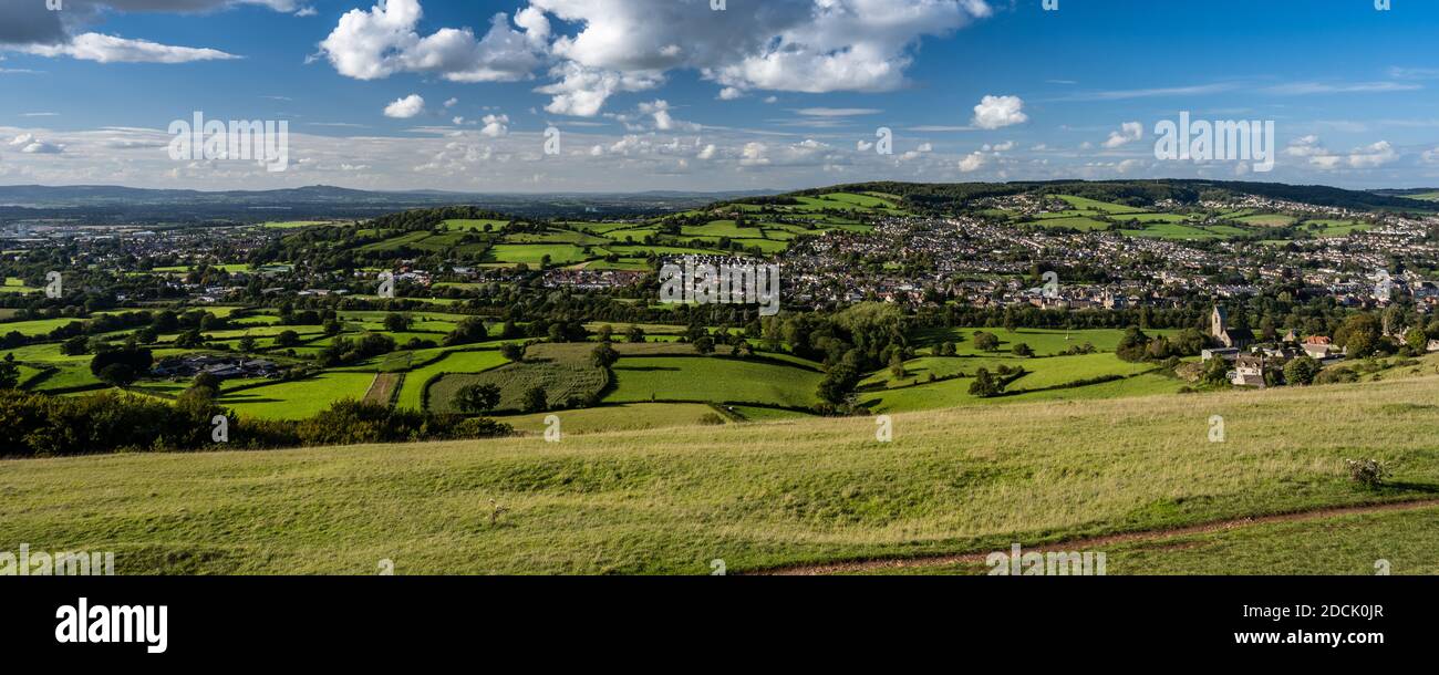 Sun shines on the town of Stroud, nestled in a valley under the hills of the Cotswolds in Gloucestershire, as viewed from Selsley Common. Stock Photo
