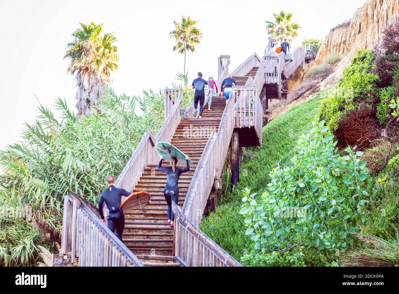 Surfers using the stairs that lead to a surfing spot at San Elijo State Beach. Encinitas, California, USA. Stock Photo