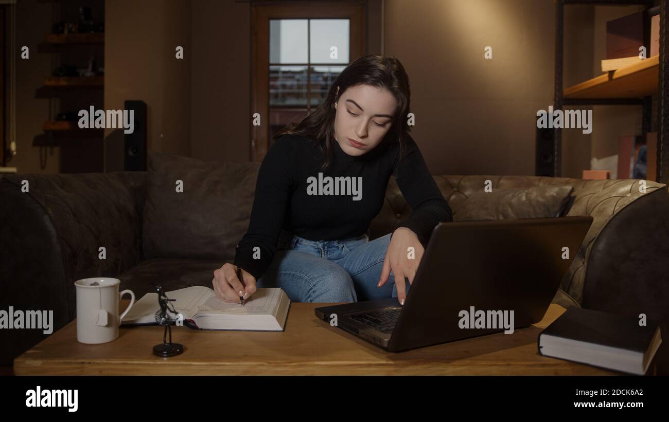 Bored college or high school student pretty girl studying at table with ...