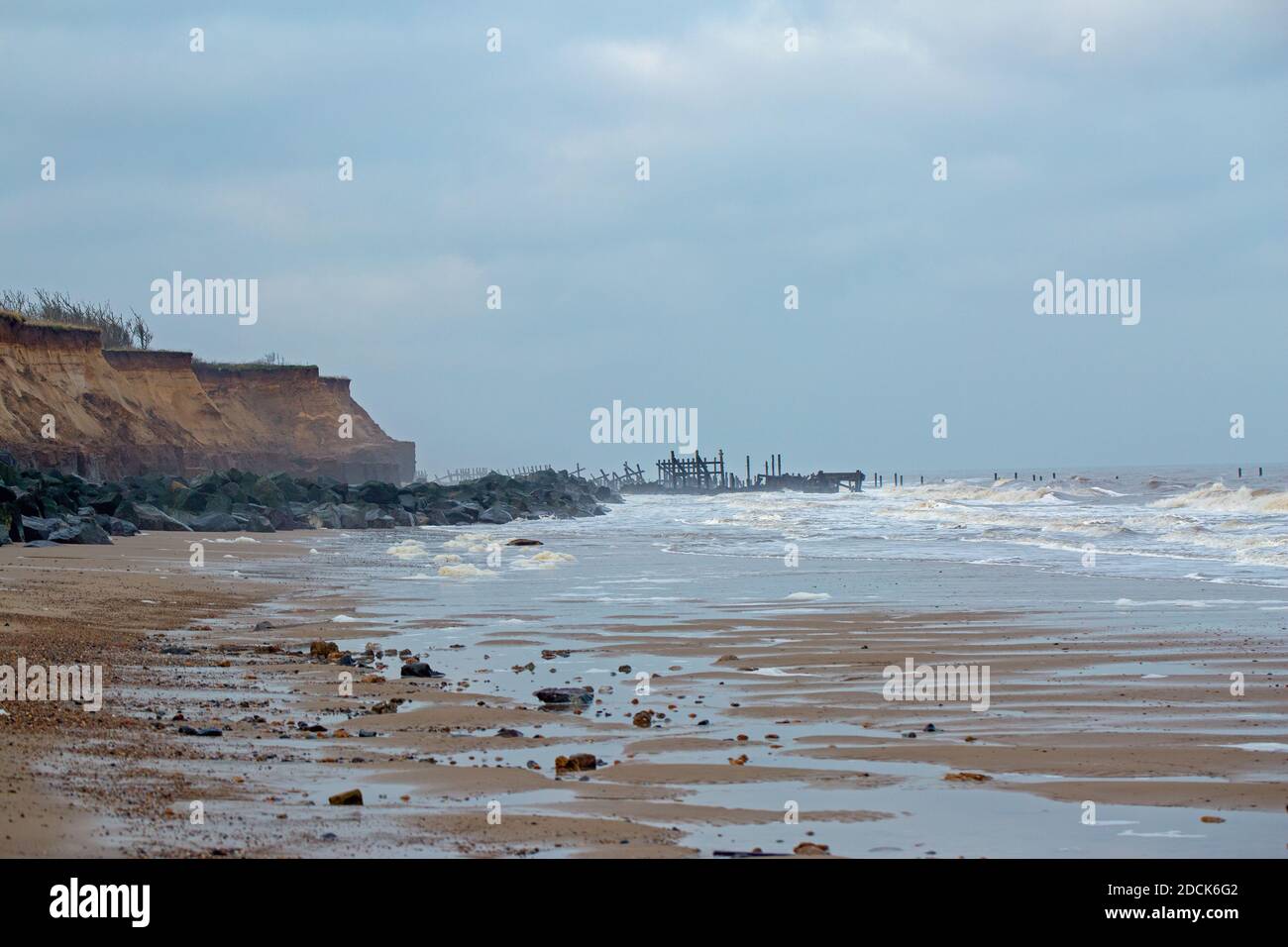 Happisburgh beach, Norfolk. Coastal cliff erosion by the North Sea. Destroyed brick built house material on the beach. Sea defences of imported Norway Stock Photo