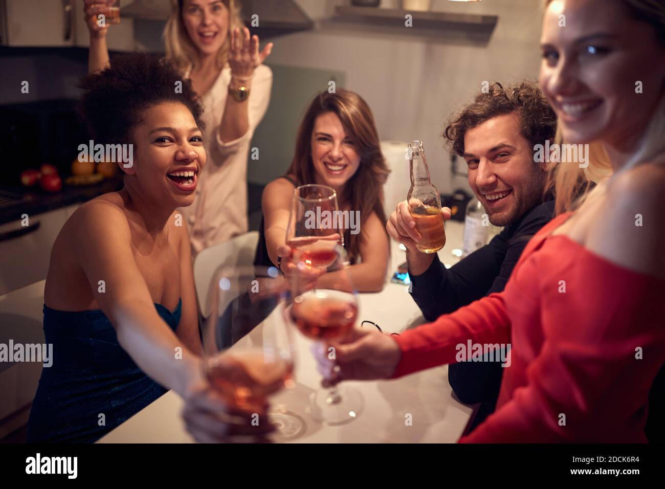 Cheerful group of friends having a New Year party at home. Corona, covid concept Stock Photo