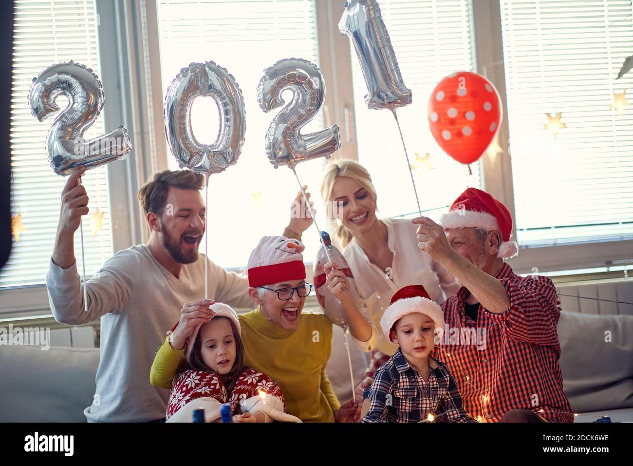 Cheerful family having fun at New Year eve home party in festive