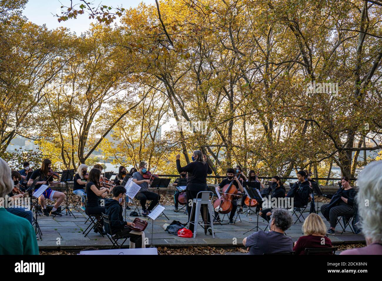 Outside Musical Performance New York City, NY - November 15 2020: Young musicians and conductor ...