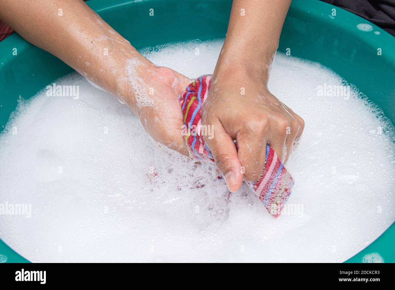 Female hands wash clothing by hand with detergent in the basin. selective focus and space for text. Stock Photo