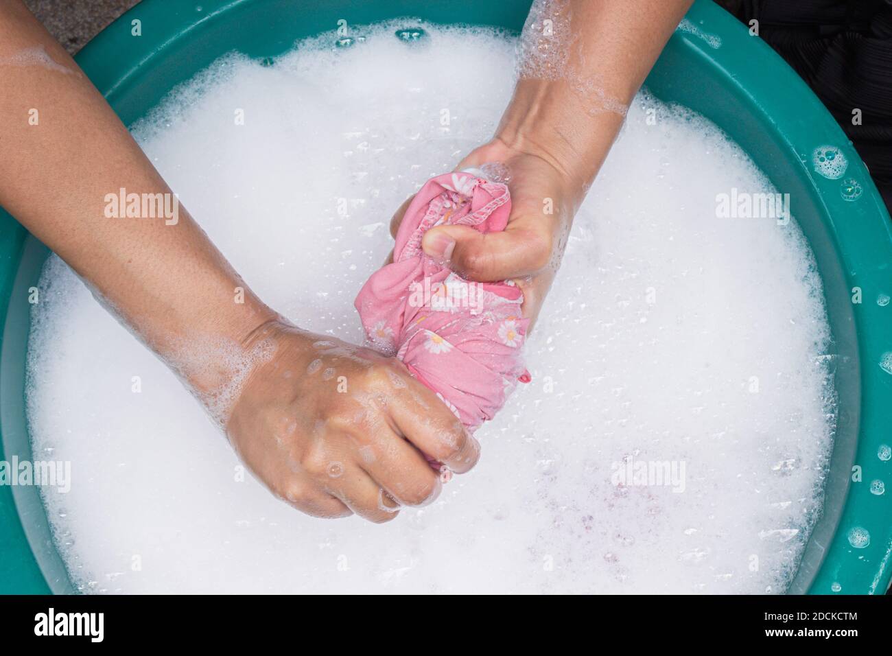 Females hands wash clothing by hand with detergent in the basin. selective focus and space for text. Stock Photo
