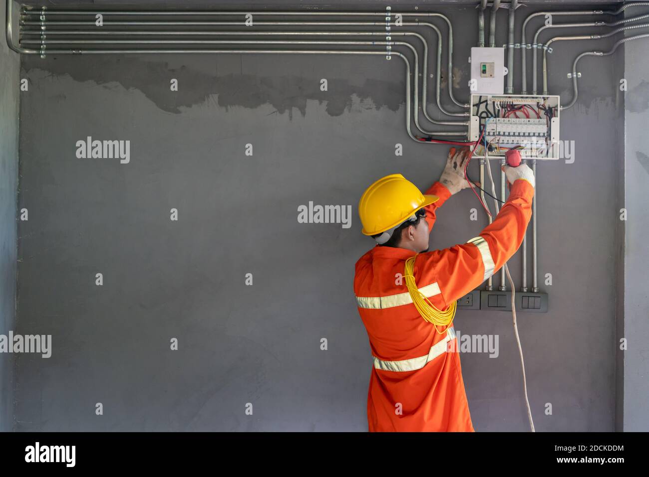 Asian electrician wear safety clothes with electric screwdriver ...