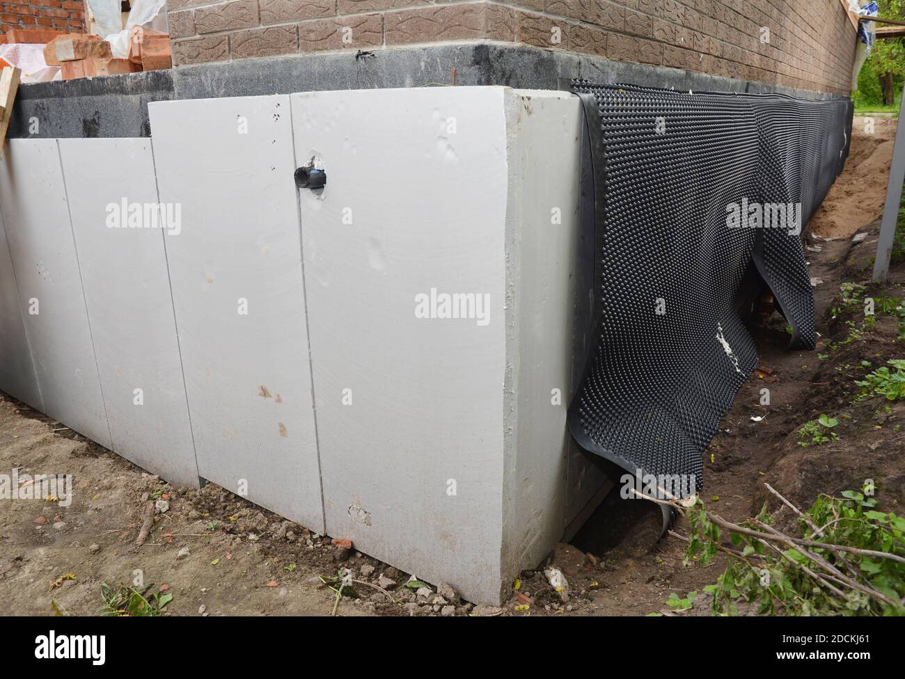 Foundation wall insulation, damp proofing on the house corner. House
