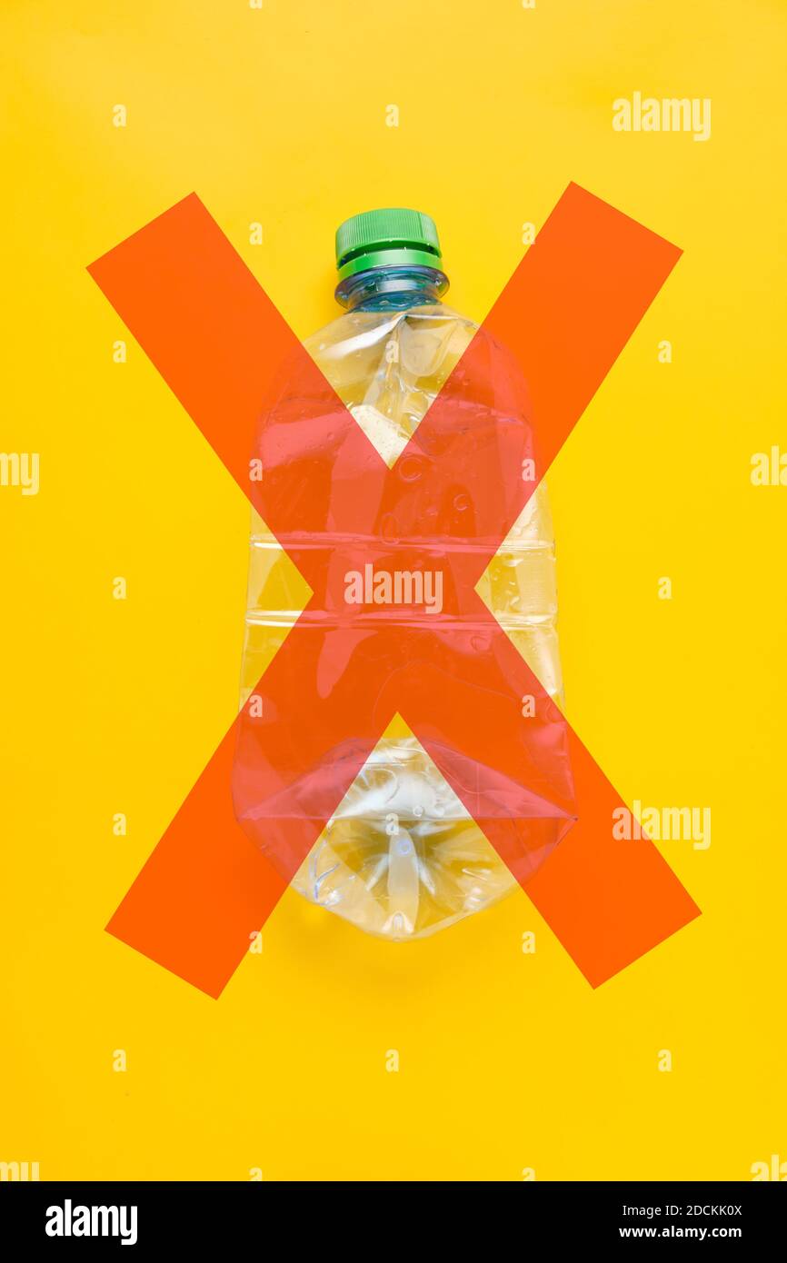 Used plastic bottle of water with caps x mark on yellow background
