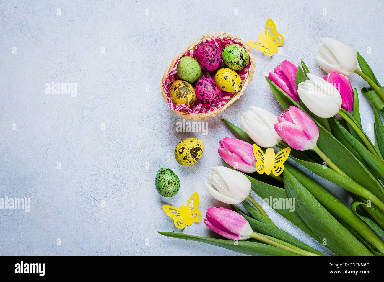 Easter Background with white and pink tulips and colorful quail eggs on ...