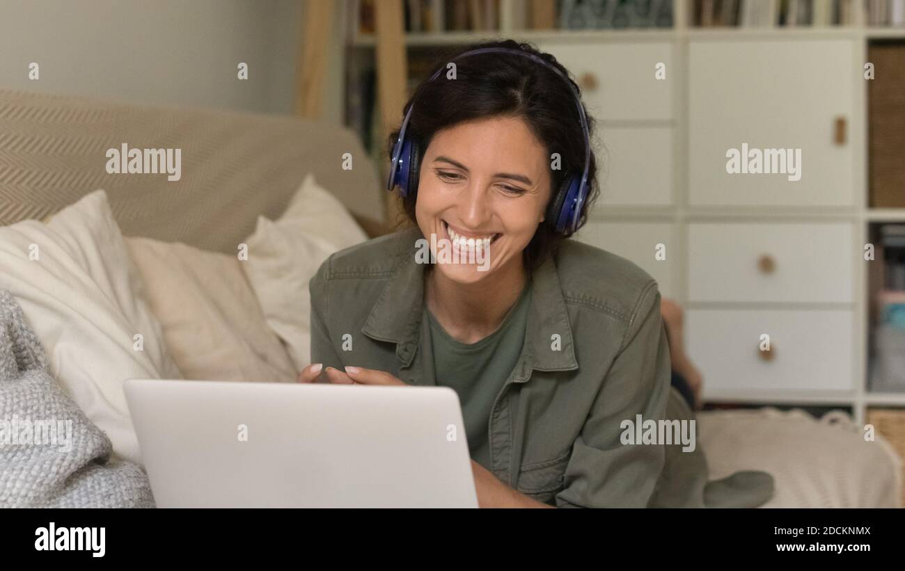Smiling woman in earphones talk on video call on laptop Stock Photo - Alamy