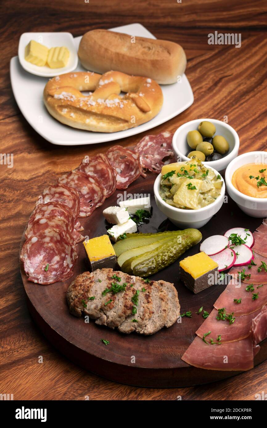 german cold cuts tapas snack platter with meats and bread on wood table ...