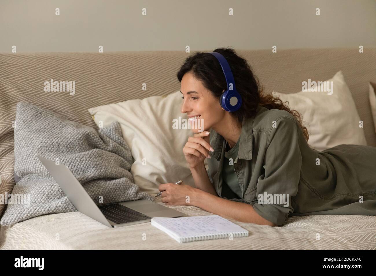 Smiling woman in headphones study online from home Stock Photo