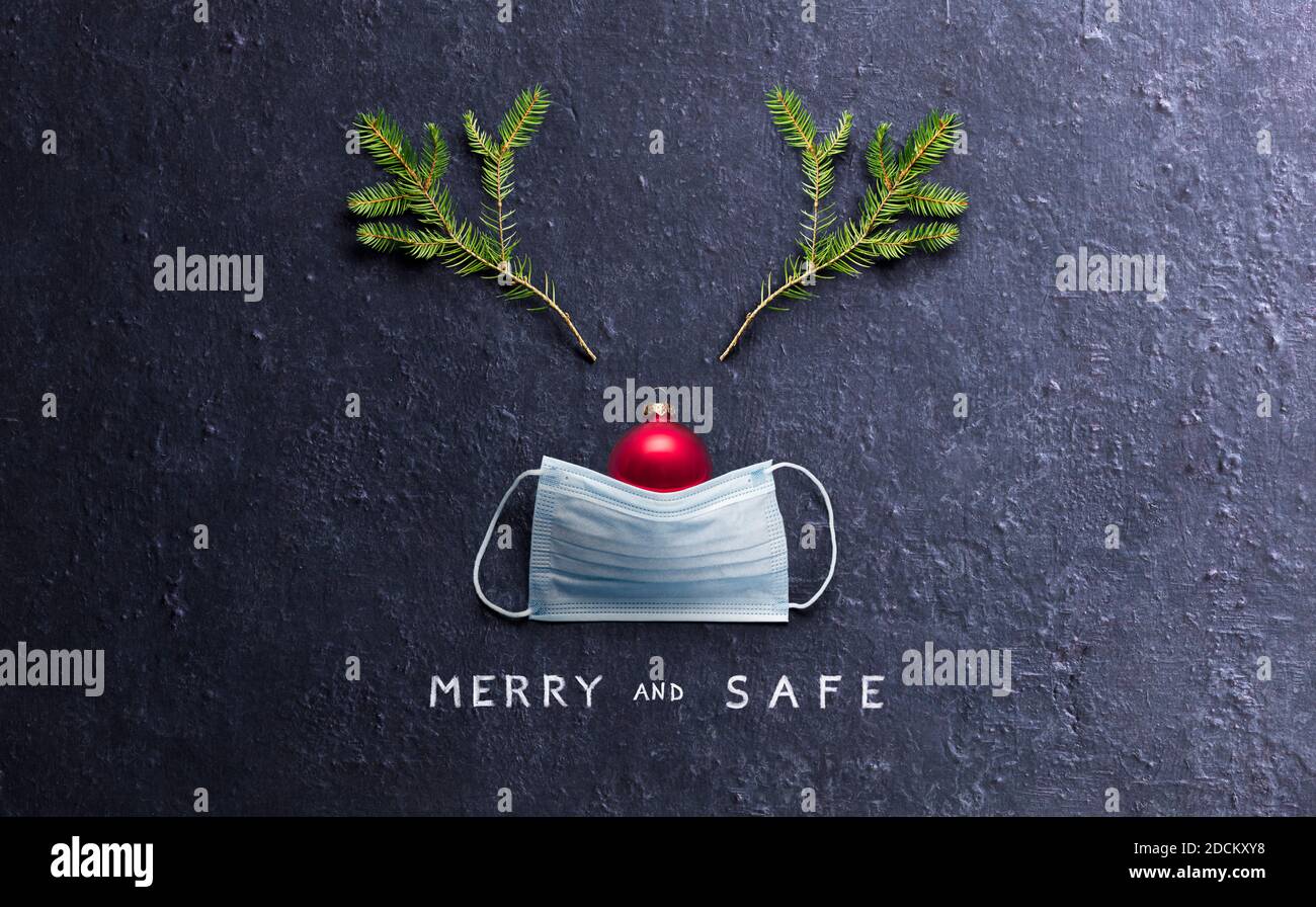 Minimal Christmas Concept - Merry And Safe - Reindeer Made With Face Mask And Decorations Stock Photo