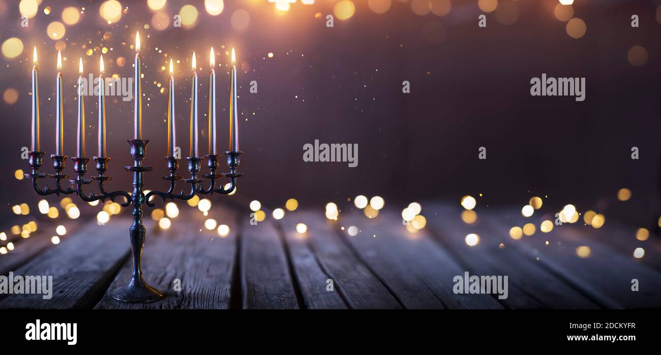 Hanukkah Abstract Defocused Background - Menorah With Bright Dust On Wooden Table Stock Photo